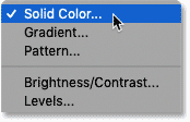 Выберите слой заливки сплошным цветом на панели «Слои» в Photoshop.